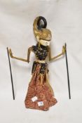 A decorative Japanese/Indonesean puppet having carved wooden body and head with painted detailing.