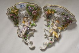 A pair of Sitzendorf porcelain wall brackets with floral and cherub designs