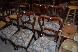 A set of six Victorian mahogany balloon back dining chairs with later upholstered seats