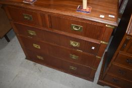 A modern campaign style chest having three drawers and one faux drawer drop flap