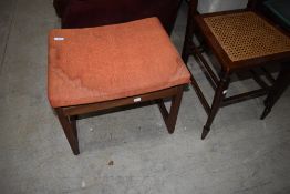 A vintage teak stool with orange seat covering, E Gomme (G plan)