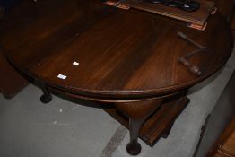 An early 20th Century mahogany oval dining table having wind out extensions with two further leaves,