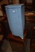 A Lloyd Loom corner linen basket and a vintage bedside cabinet