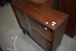 A vintage sapele bookcase having sliding doors
