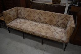 A late Victorian settle having turned mahogany legs and floral upholstery, width approx. 197cm