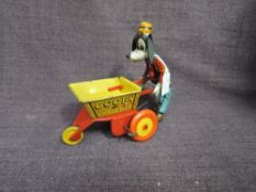 A 1950's Louis Marx clockwork and tinplate Goofy The Gardener, Goofy pushing barrow