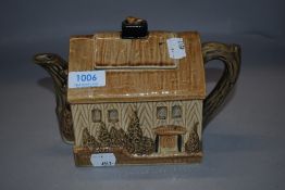 An early 20th century novelty tea pot in the form of a country cottage, lid being damaged.