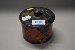 A William Moorcroft lidded pot. Stamped to base 'Burslem 107' and signed. AF