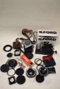 A box of camera filters, light meters, lenses and covertors