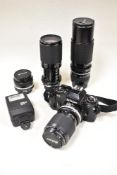 A Nikon FG camera with Nikkor 35-105mm 1:3,5-4,5 lens, a Tamron 70-210mm 1:3,8-4 lens, a Nikkar 50mm