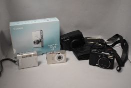 Three digital cameras. A Canon G9 with Canon zoom 6X IS 7.4-44.4mm 1:2,8-4,9, a Canon IXUS60 with