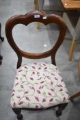 A set of four Victorian mahogany dining chairs having shaped balloon backs, turned legs and later