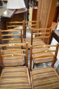 A set of six 1970s teak dining chairs, having three shaped horizontal rails, bearing paper label and