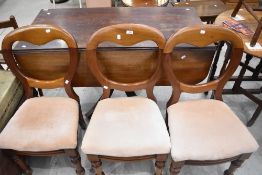 A group of three Victorian mahogany balloon-back dining chairs, pegged at the back legs and