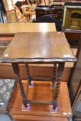 An Edwardian plant stand having an oak frame with barley twist legs and pie crust top.