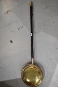 A traditional brass and copper bed warming pan