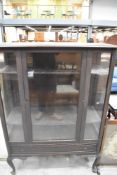 A glazed mahogany display cabinet, of traditional design with adjustable shelving and raised on