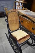An early 20th century continental stained bentwood rocking chair, in the manner of Thonet, with