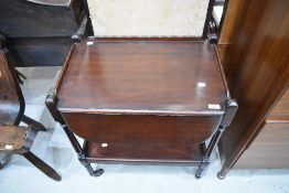An Edwardian drop leaf tea trolley having a Mahogany frame.