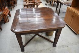 An early 20th Century oak drawer leaf dining table having tapered legs and X stretcher