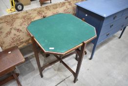 An early 20th Century patented 'Improved Revertable' folding table having octagonal tea/card table
