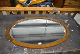 An early 20th Century mahogany oval wall mirror, maximum diameter approx. 95cm