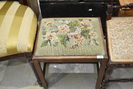 A traditional oak stool having tapestry seat