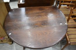 An Ercol dark elm drop leaf dining table, lacking label