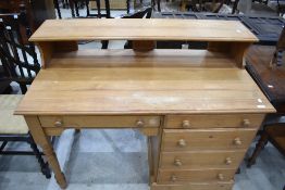 A modern pine desk with raised back over the kneehole and bank of drawers 87cm x 121cm