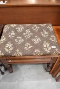 A modern piano stool having carved and turned Mahogany frame with seat storage.
