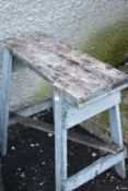 A small wooden trestle style work bench
