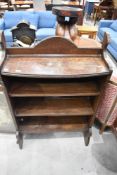 A 1940's oak open bookcase with bead moulding and shaped ends and surmount 116cm
