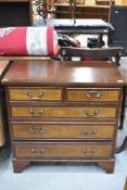 A modern chest of two over three drawers with inlayed drawer fronts.