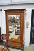 A Victorian and later armoire style wardrobe having mirror door and inlaid decoration and paw feet