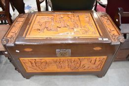 A traditional Oriental camphor wood blanket box having typical carved decoration