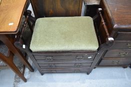 A late Victorian piano stool having seat storage and double under drawers with turned twin handles.