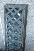 A pair of metal drain or similar grids, in trellis form