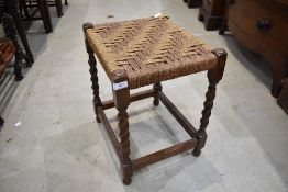 A traditional Beech framed stool with barley twist legs and woven seat top