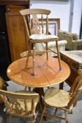 A circular dining table and set of four traditional beech kitchen chairs