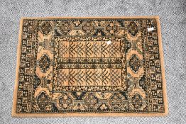A modern small sized wool rug in black and brown grounds in an Afghan weave 85cm x 60cm