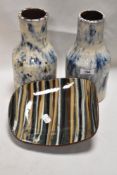 A pair of early 20th century slip glazed bottle form vase with a three footed studio pottery dish