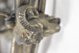An antique brass ceiling light fixture with lion head decals and central three branch light.