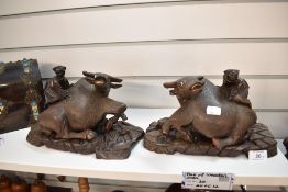 A pair of early 20th century Burmese wooden carved mirrored water Buffalo figures on wooden bases.