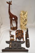 Two hand painted giraffe figures with a similar wall sconce a Middle Eastern mask plaque and a