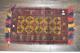 A 20th century Persian Afghan Belouch saddle bag in woven wool in a brown and red ground with