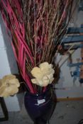 A vase with artificial flowers and lights