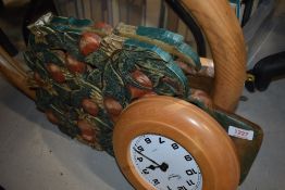 A pine framed oval mirror an ash wood framed clock and a decorated carved wall plaque in plant form