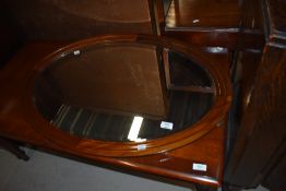 An early 20th Century mahogany oval wall mirror of plain form, diameter approx. 85cm