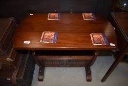 A reproduction oak magazine table, with linen fold decoration to lower