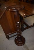 A modern stained frame plant stand having turned column